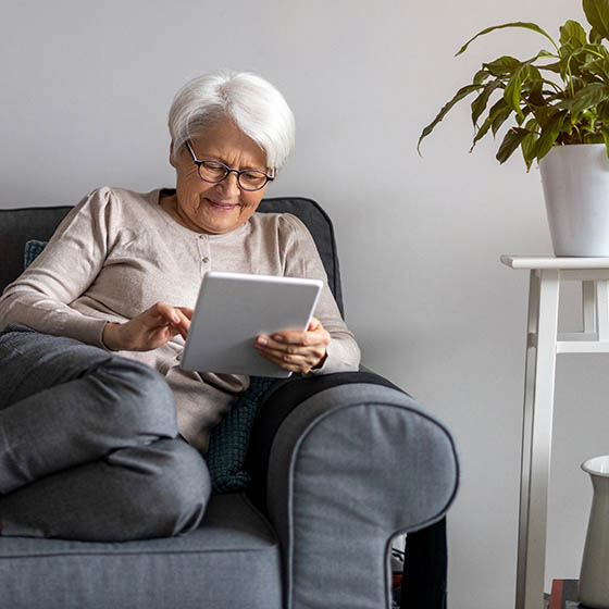 Woman sitting on couch and using a tablet